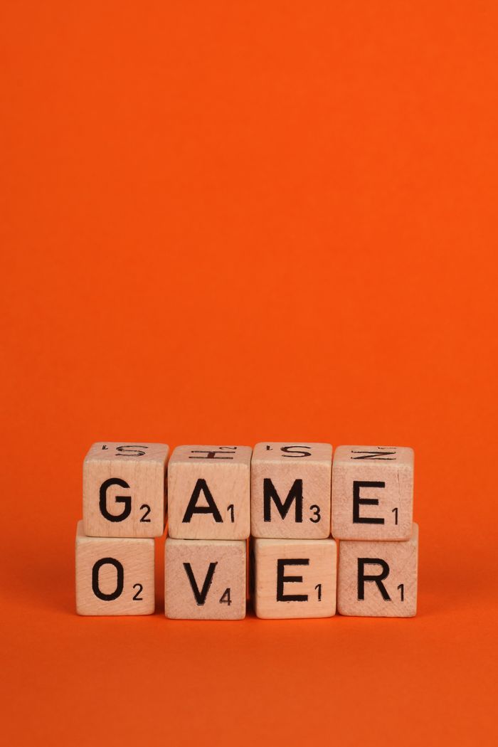 Scrabble tiles spelling 'Game Over' against an orange backdrop.